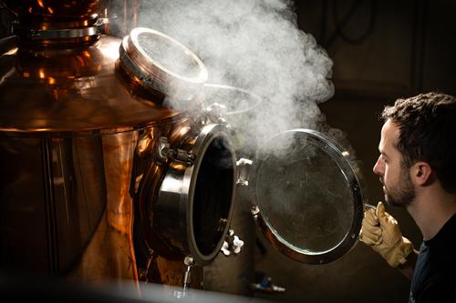 Steam rising from the still on a production day
